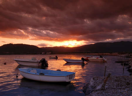 Beautiful sunset over harbor with dramatic sky on Sardiniaの写真素材