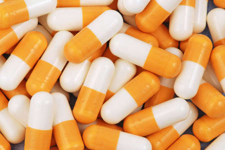 Yellow and white medical capsules on the one heapの写真素材
