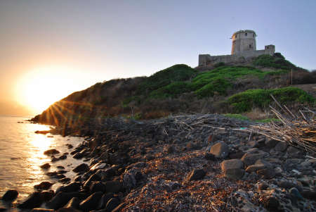 Ancient Sardinian castle on the coast during the sunriseの写真素材