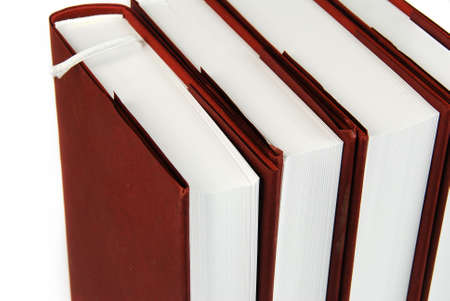 Stack of four same books with brown cover isolated on whiteの写真素材