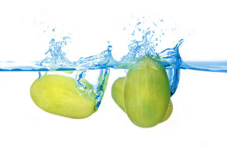Fresh healthy green balls of grapes falling in the blue waterの写真素材
