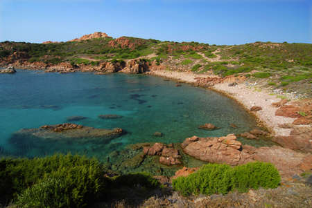 Beautiful bay of red rocks on Sardinia near the village Isola Rossa and emerald water of the seaの写真素材