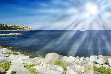 Beach surrounded by rocks with a blue sky. Panorama