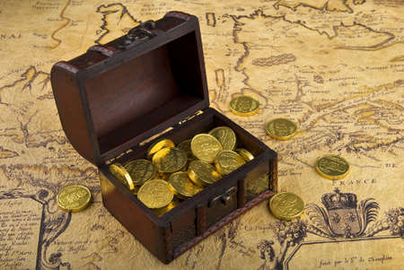 Very old map with treasure chest full of golden coins on a vintage mapの写真素材