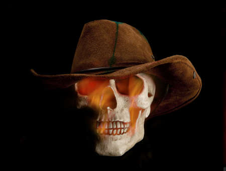 Scary flaming human skull is wearing cowboy hatの写真素材