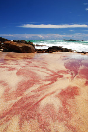Tropical paradise on Sri Lanka with the very special sandy - yellow and red beach, turquoise sea and boulders in the frontの写真素材