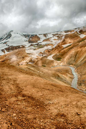 Iceland is a land of ice and fire. In the geothermal area Kerlingarfjoll one can see smoke and boiling fumaroles from the geothermal field as well as mountains covered by ice and snow.の写真素材