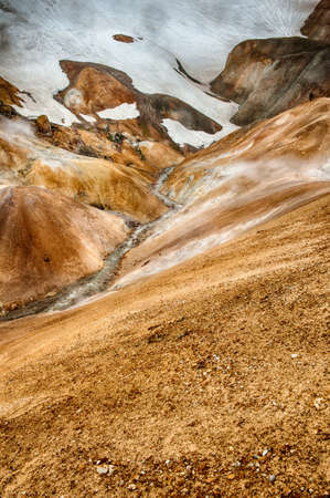 Iceland is a land of ice and fire. In the geothermal area Kerlingarfjoll one can see smoke and boiling fumaroles from the geothermal field as well as mountains covered by ice and snow.の写真素材