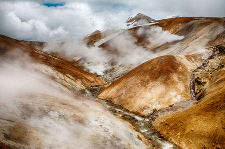 Iceland is a land of ice and fire. In the geothermal area Kerlingarfjoll one can see smoke and boiling fumaroles from the geothermal field as well as mountains covered by ice and snow.の写真素材