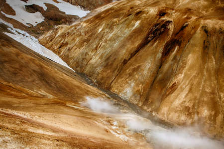 Iceland is a land of ice and fire. In the geothermal area Kerlingarfjoll one can see smoke and boiling fumaroles from the geothermal field as well as mountains covered by ice and snow.の写真素材