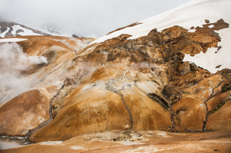 Iceland is a land of ice and fire. In the geothermal area Kerlingarfjoll one can see smoke and boiling fumaroles from the geothermal field as well as mountains covered by ice and snow.の写真素材