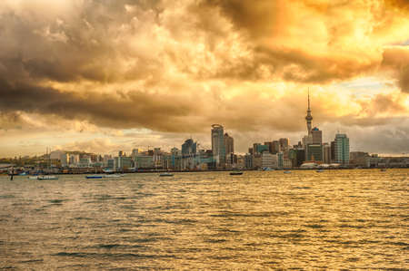 Skyline photo of the biggest city in the New Zealand, Auckland. The photo was taken during the golden sunset across the bayの写真素材