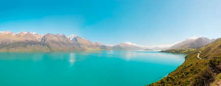 Beautiful blue lake Wakatipu with mighty Southern Alps mountains on horizon. Otago region, New Zealand. Panoramic photoの写真素材