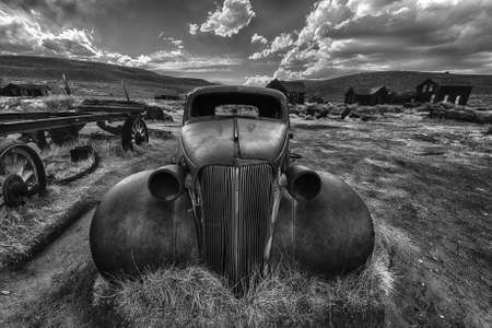 Wreck of a ancient rusty car in a ghost town of Bodie. Bodie is a National Historic Landmark. It is located in Mono County, Sierra Nevada - California. United States of America.の写真素材