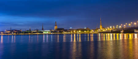 Skyline of Riga seen across the river Daugava after the sunset. The tallest building on the picture is the St. Peter's Churchの写真素材