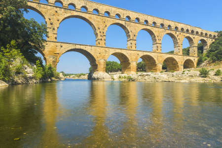 Pont du Gard is an old Roman aqueduct, southern France near Avignon. Reflection in the river Gardの写真素材