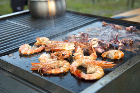 Summer barbecue of seafood - shrimps and octopus. Shallow DOFの写真素材