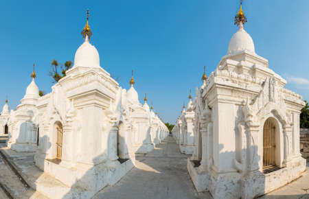 Kuthodaw Pagoda contains the worlds biggest book. There are 729 white stupas with caves with a marble slab inside - page with buddhist inscription. Panoramic photo. Mandalay, Myanmarの写真素材