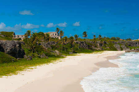 Harrismith Beach is one of the most beautiful beaches on the Caribbean island of Barbados. It is a tropical paradise with palms hanging over turquoise sea and a ruin of an old mansion on the cliffの写真素材