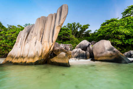 Beautifully shaped granite boulders and a dramatic sunset  at Anse Source d'Argent beach, La Digue island, Seychelles. Long exposure with blurred seaの写真素材