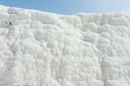 Pamukkale (cotton castle) natural wonder is created by a layers of white travertine looking like cotton, Turkey. Natural pamukkale wall against a blue skyのeditorial素材