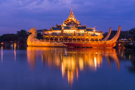 Golden Karaweik palace on Kandawgyi lake looks like an ancient royal barge. Twilight time. Yangon, Myanmarのeditorial素材