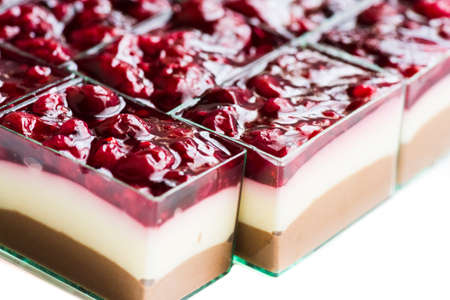 Chocolate and vanilla mousse cakes covered by various berries on white