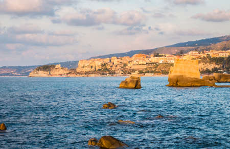 Sun is setting over a rocky coast at beach near Tropea, Southern Italyの写真素材