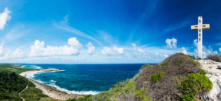 Cross, rocks and view at sea at Pointe des Chateaux, the most Eastern point of French island  of Guadeloupein the Caribbean. Panoramaの写真素材