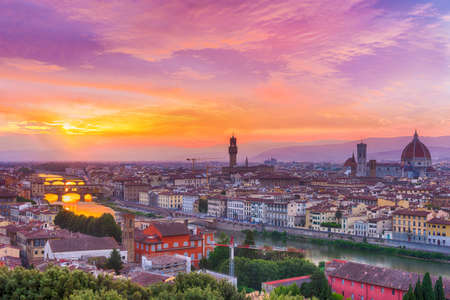 Vivid sunset over river Arno in Florence seen from Michelangelo square. In the picture could be seen Cathedral Santa Maria del Fiore, city hall Palazzo Vecchio and famous bridge Ponte Vecchioの写真素材