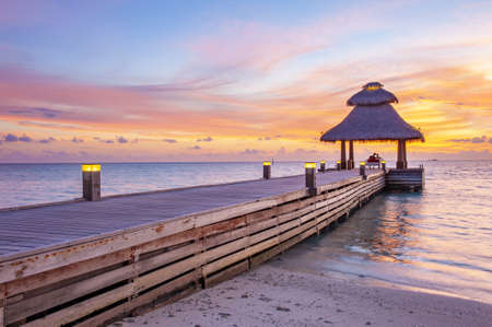 Awsome vivid sunset over the jetty in the Indian ocean, Maldives. HDRの写真素材