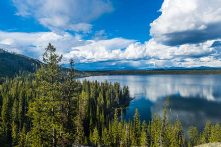 Beautiful crystal clear water of the Jenny Lake seen from above with clouds reflecting in water. Wyoming, Grand Teton National Park, USA.の写真素材