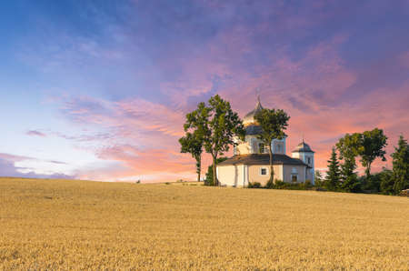 Beautiful 17th century baroque church of Saint Barbara. Building of octagonal shape is standing on the hill in the middle of fields under the setting sun. Procevily village near Breznice town in the Czech Republicの写真素材