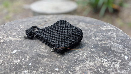 Handmade knitted woolen bracelet with a black thread on a stone