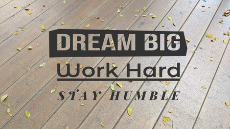 A motivational message DREAM BIG, Work Hard, STAY HUMBLE overlaid on a wooden floor with scattered leaves, inspiring ambition, effort, and modesty.の写真素材
