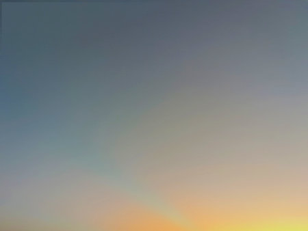 A vibrant gradient sky, transitioning from a deep blue at the top to a bright orange and yellow at...