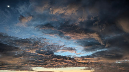 A dynamic sky with a crescent moon in the upper left corner. Layers of textured clouds in dark gray...