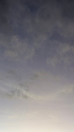 A smooth gradient sky transitions from a deep, dusky blue to a soft, hazy peach at the bottom. A few...
