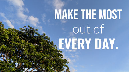 Quote, MAKE THE MOST out of EVERY DAY, is displayed over a bright sky. Lush green leaves from a tree fill the bottom left, while the rest of the frame is a clear blue sky with white clouds.の写真素材