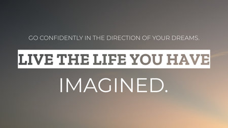A serene quote reading &#39;GO CONFIDENTLY IN THE DIRECTION OF YOUR DREAMS. LIVE THE LIFE YOU HAVE IMAGINED&#39; set against a soft, blurred background of a cloudy gray sky with a warm glow at the bottom.の写真素材