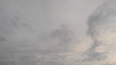 A wide shot of a sky filled with grey and white clouds.の写真素材