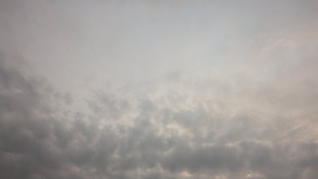 A cloudy gray sky with a gradient of light gray at the top. The lower part of the frame is filled with darker, textured clouds. The scene is atmospheric, suggesting a peaceful, overcast day.の写真素材