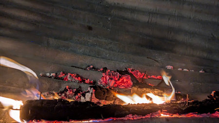 A close-up long exposure shot captures the intense heat of a fire. The bright flames and glowing red...