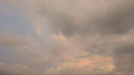 Moody overcast sky displays dense grey, tan clouds. Soft light filters through the heavy vapor,...