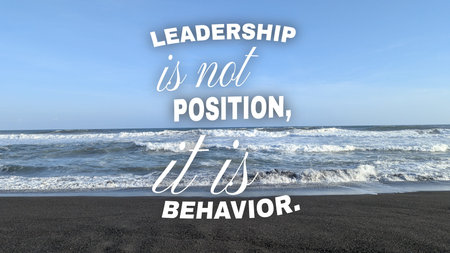 Inspirational typography layout features motivational quote text, leadership is not position it is behavior, over beautiful blue sky background. Creative text graphic design inspiration over outdoor ocean sea beach landscape scenery view with white foam waves.