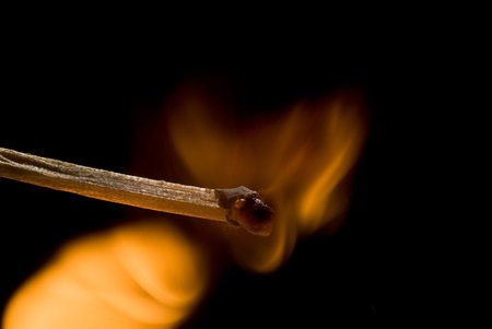 Burning match on black background