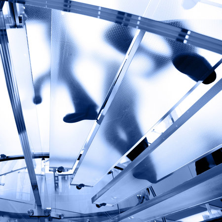 Modern glass staircase silhouette of people walkingの写真素材