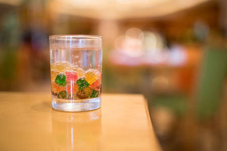 Carbonated drink with chewy candies in a glassの写真素材