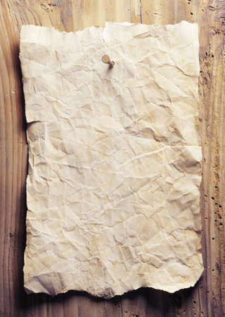 Old crumpled paper is on a wooden wallの写真素材