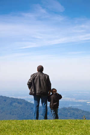 Father and son looked into the distance from the cliff.の写真素材